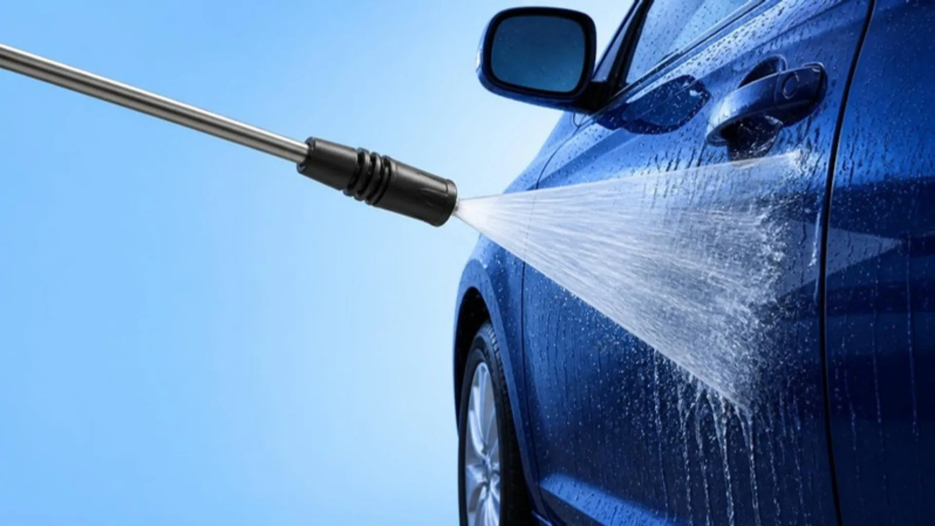 Illustration of a pressure washer wand rinsing the side of a dark blue car with a wide fan of water